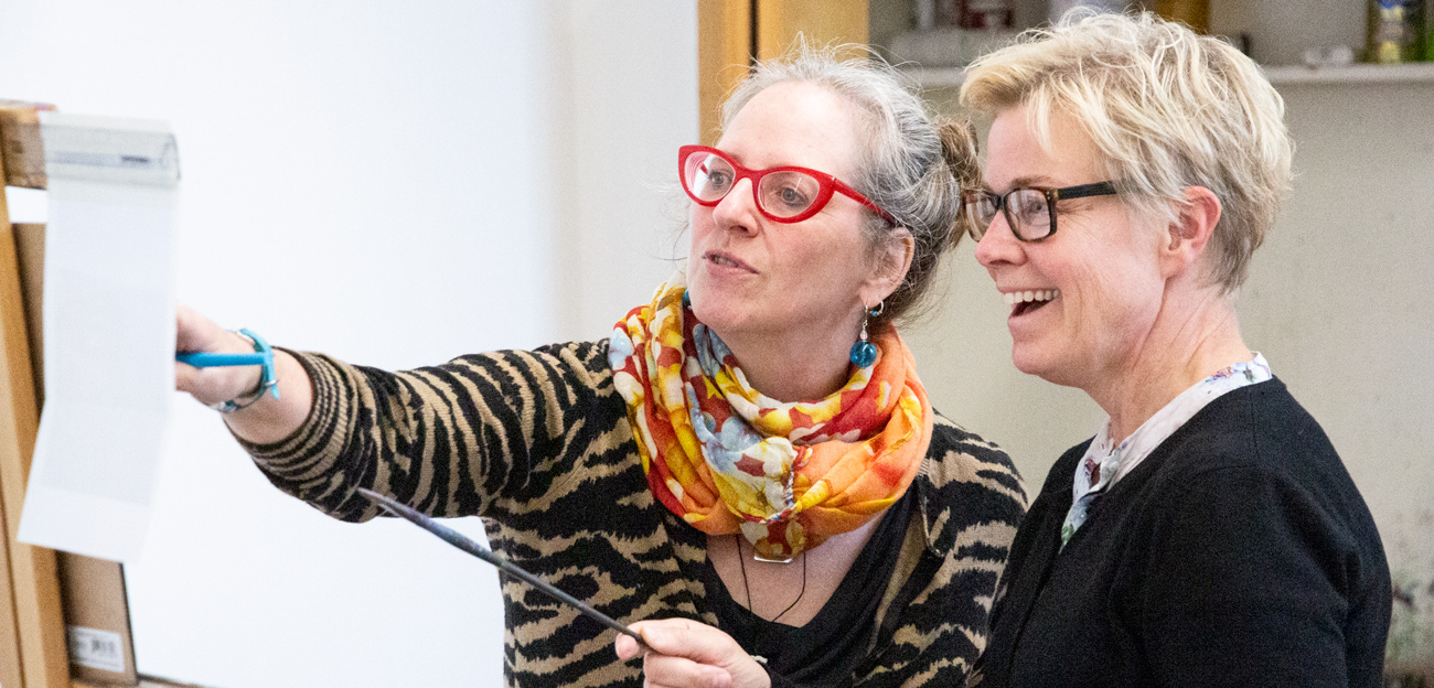 Kat Corigan guiding a student at the easel